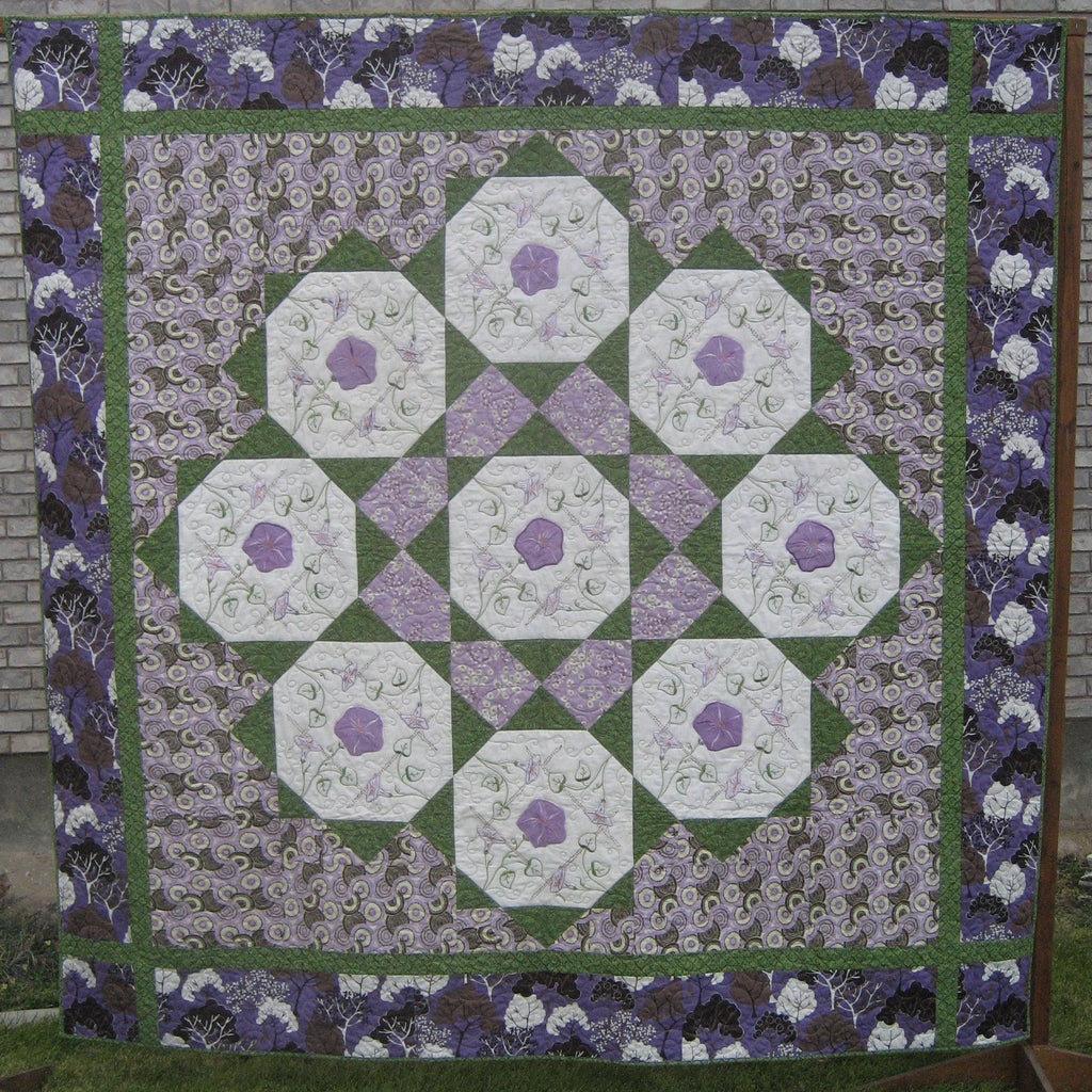 Purple and green floral checkered quilt laid out