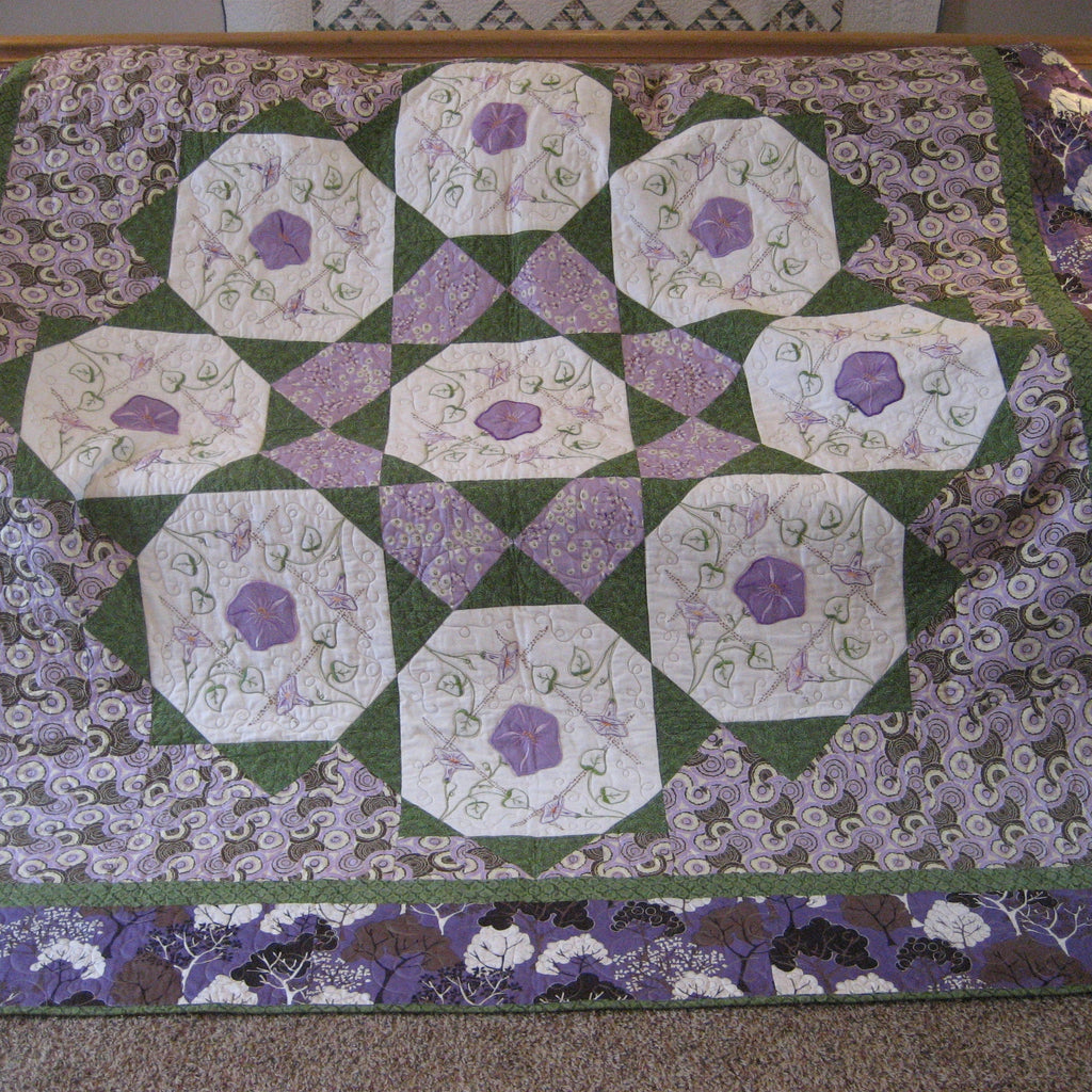 Purple and green floral checkered quilt laid out