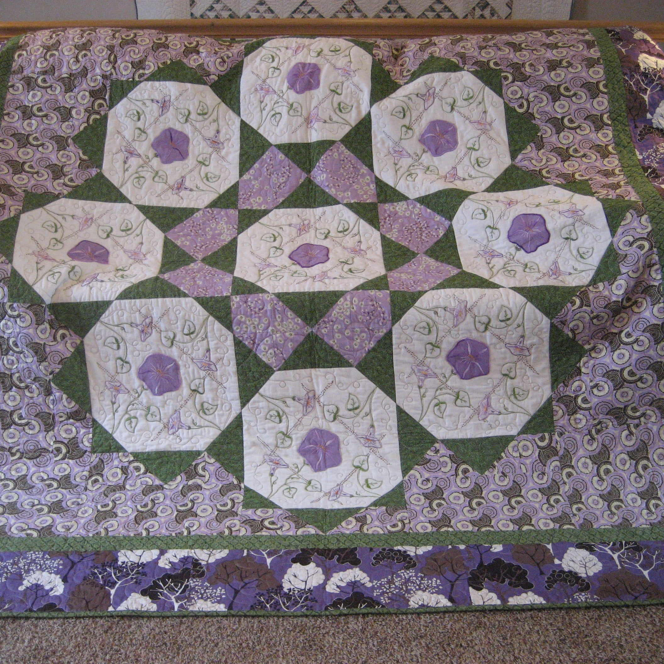 Purple and green floral checkered quilt laid out