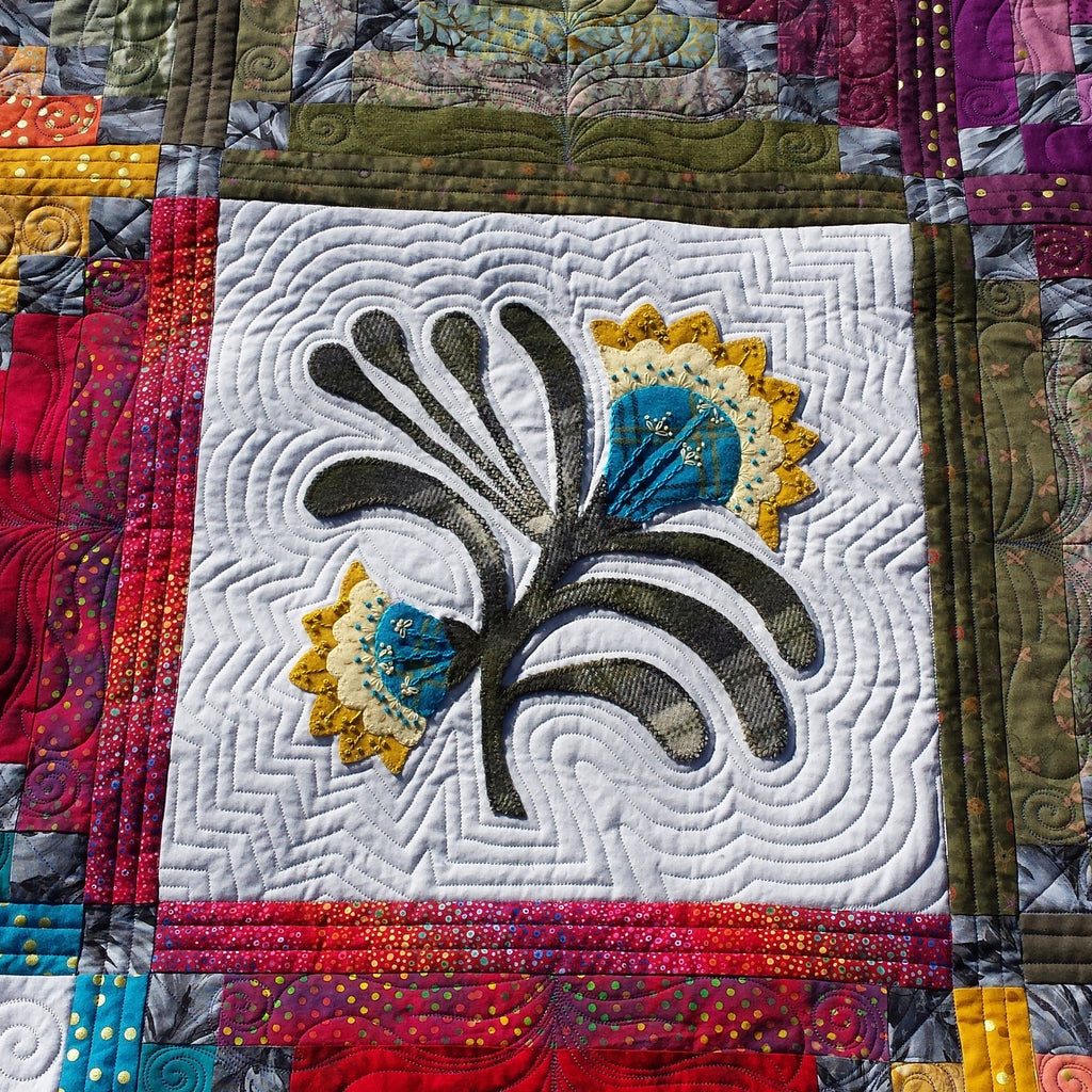Colorful quilt with a rooster design in the center