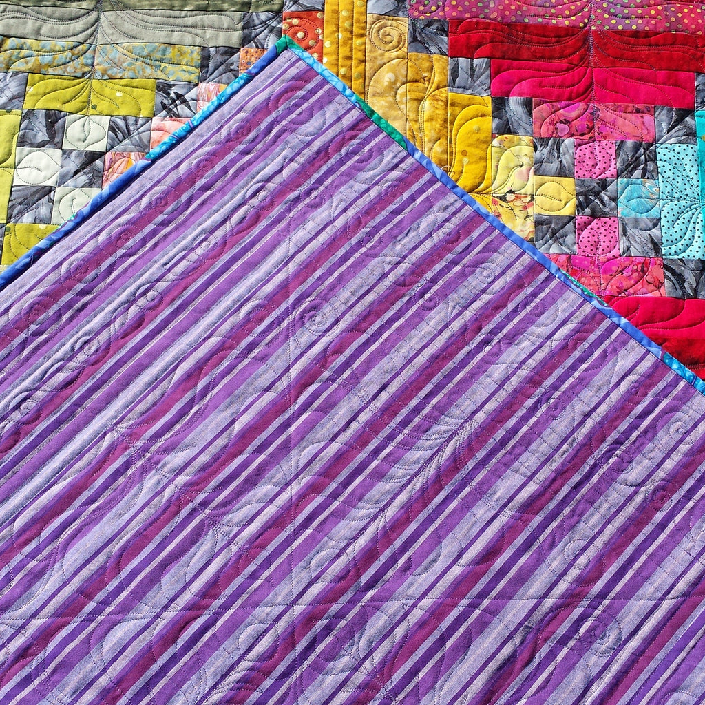 Colorful quilt with a prominent purple patchwork pattern
