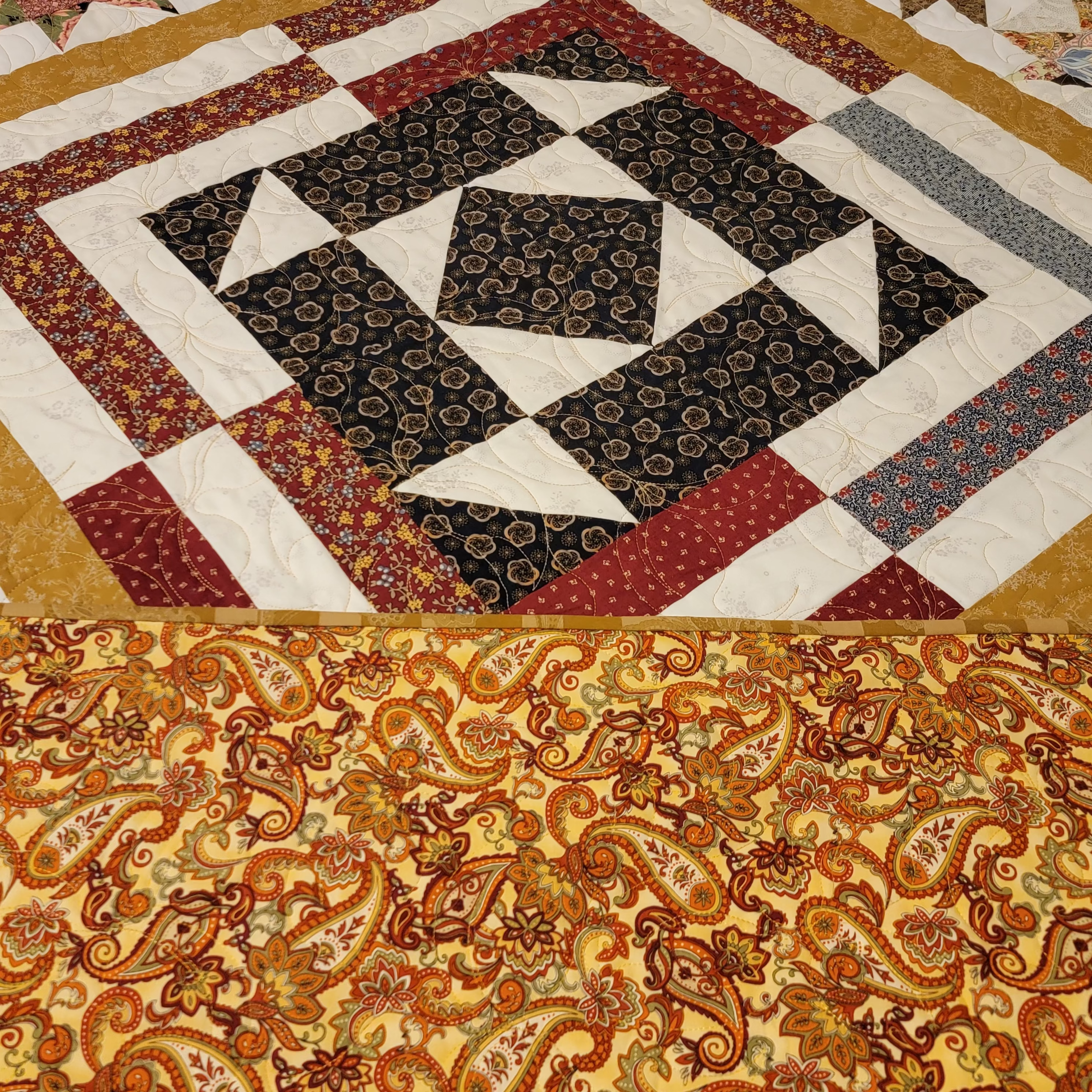 Quilt with geometric pattern and paisley design fabric