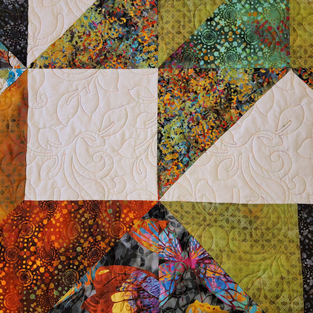Colorful quilt with geometric patterns and intricate designs.