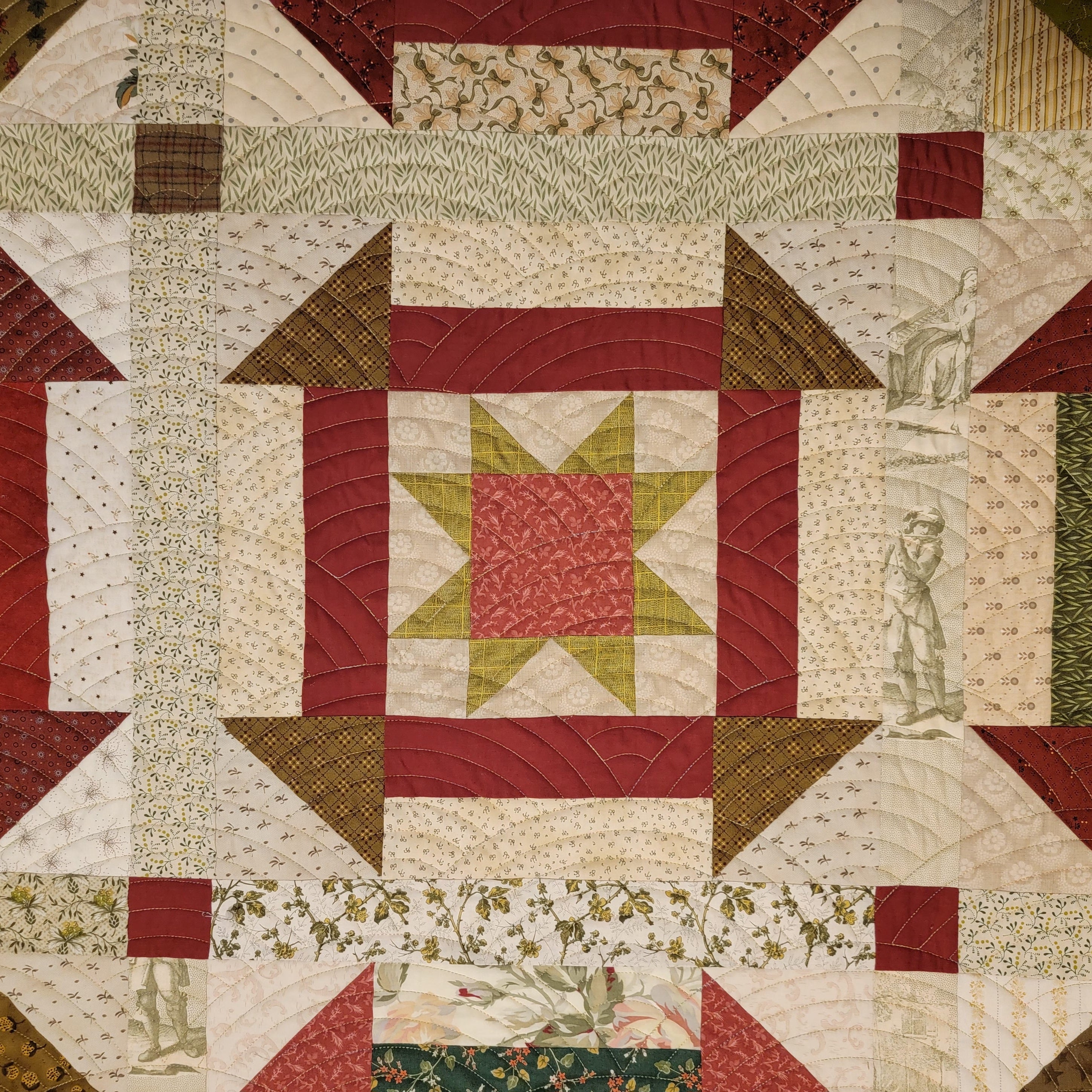 Quilt block in a churn dash pattern in red and neutral tones with floral and patterned borders