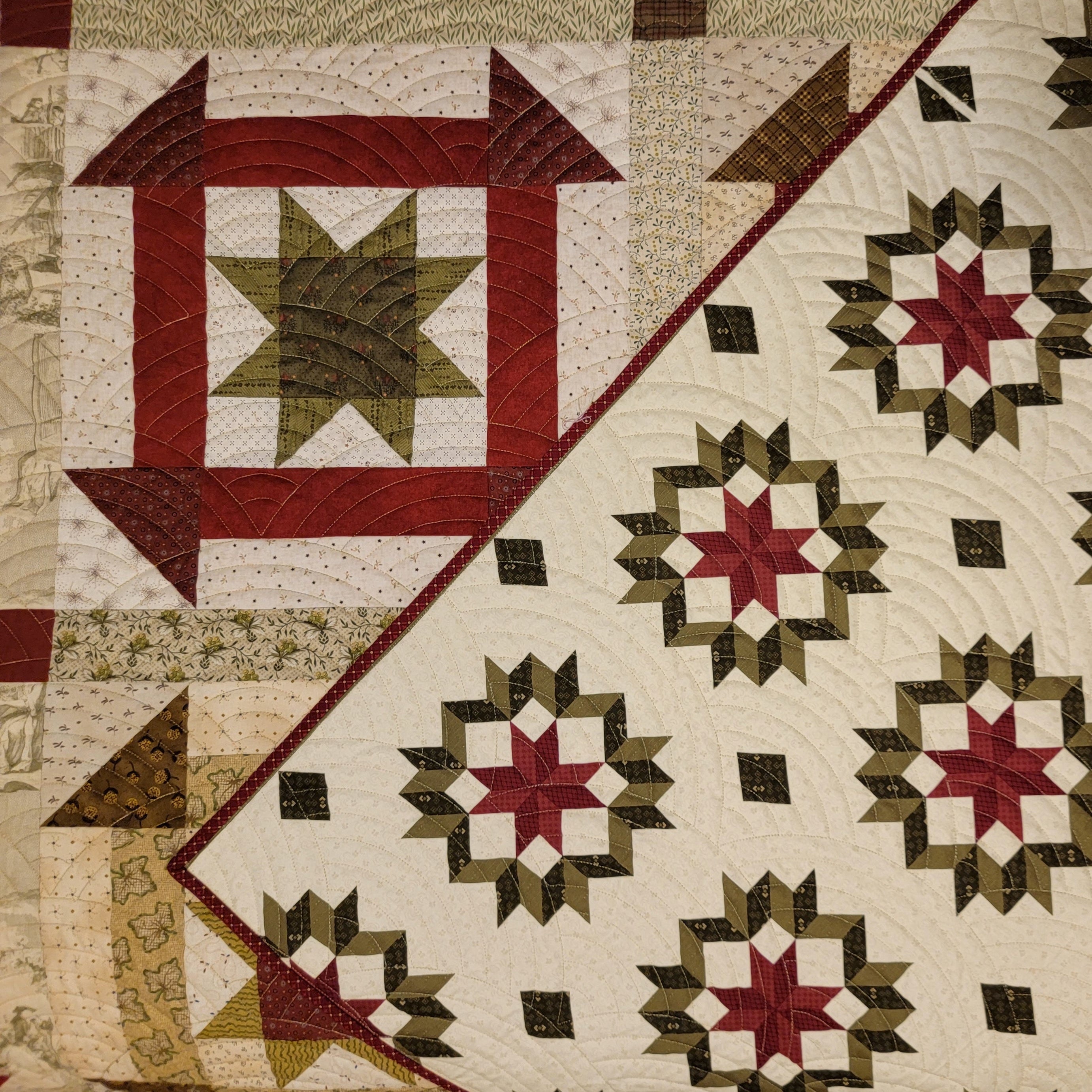 Quilt backing in a churn dash print in green and red with a larger churn dash print in the background