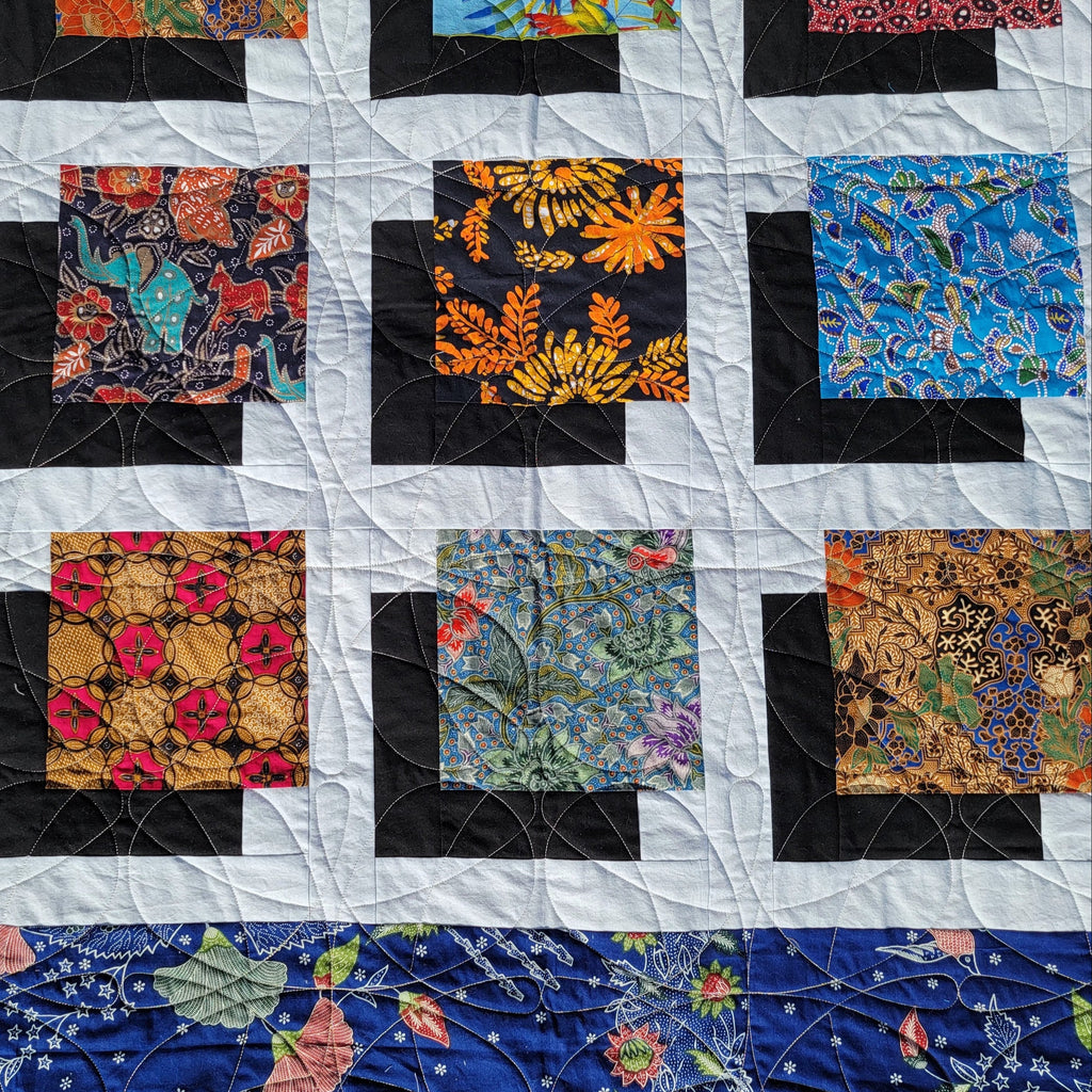 Quilt with various colorful fabric squares arranged in a pattern