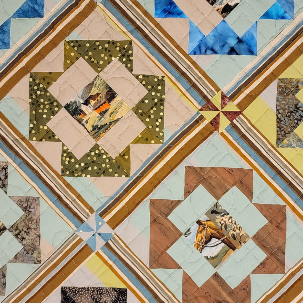 A close-up of a quilted fabric featuring a geometric diamond pattern with starburst centers. The design incorporates multiple colors and textures, including blue, olive green, tan, beige, and small printed animal motifs in the center squares.