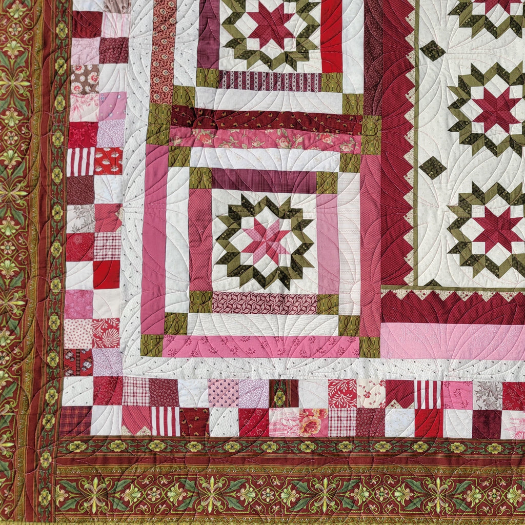 Quilt with red, pink, and green patterns