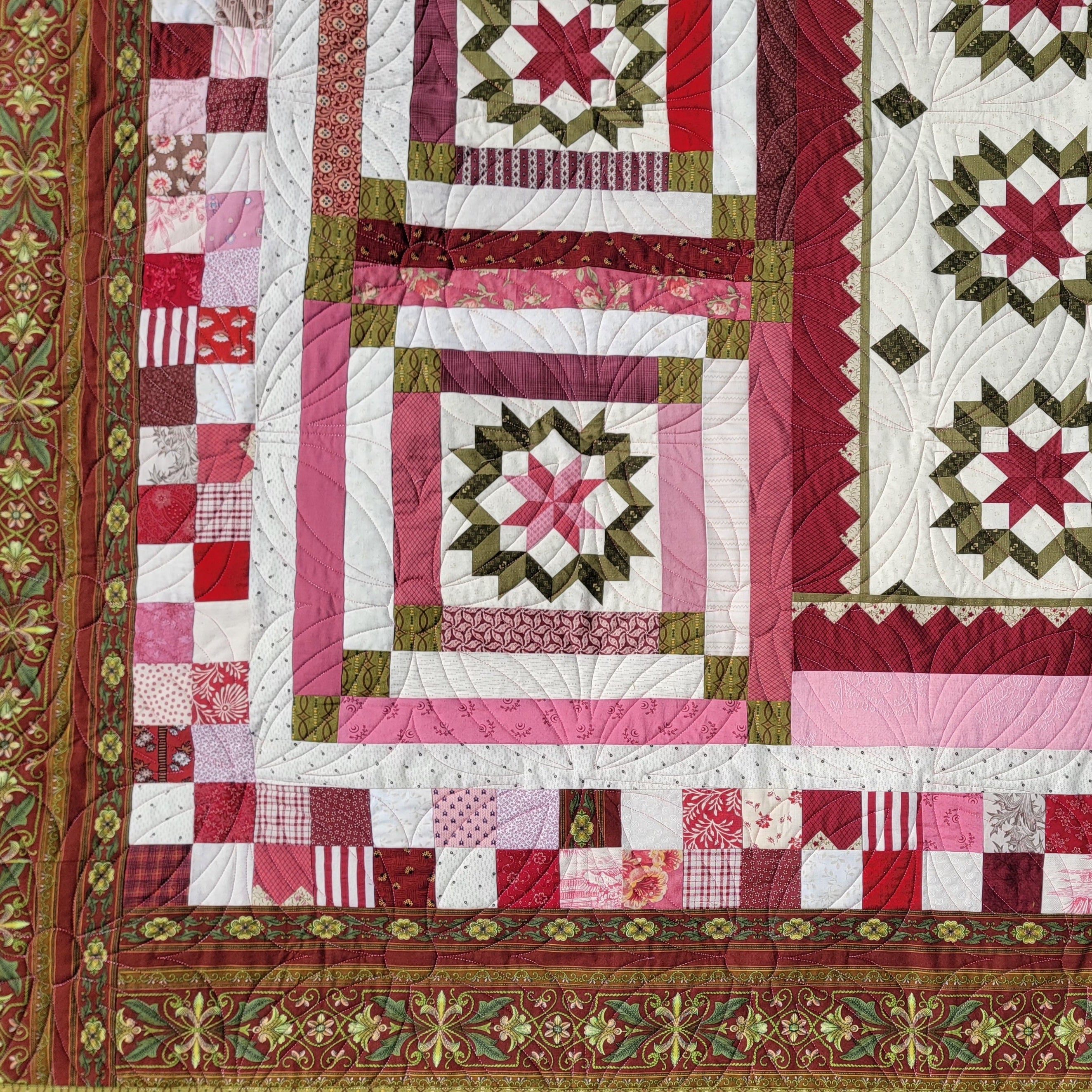 Quilt with red, pink, and green patterns