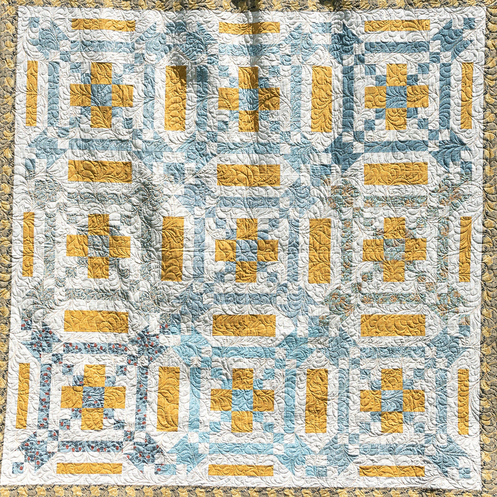 Quilt with geometric pattern in yellow and blue