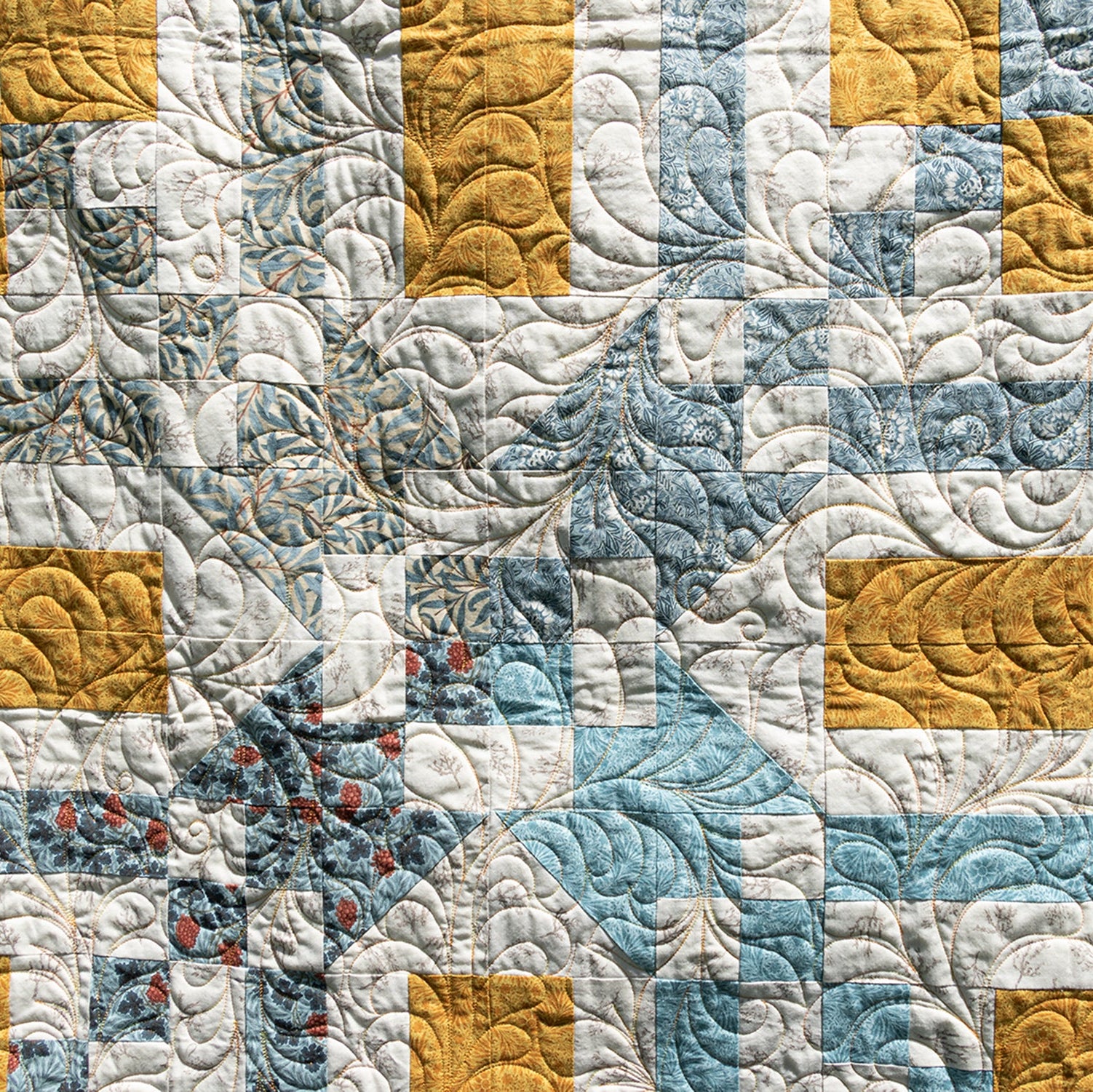 Quilt with a pattern of squares in blue, yellow, and white.