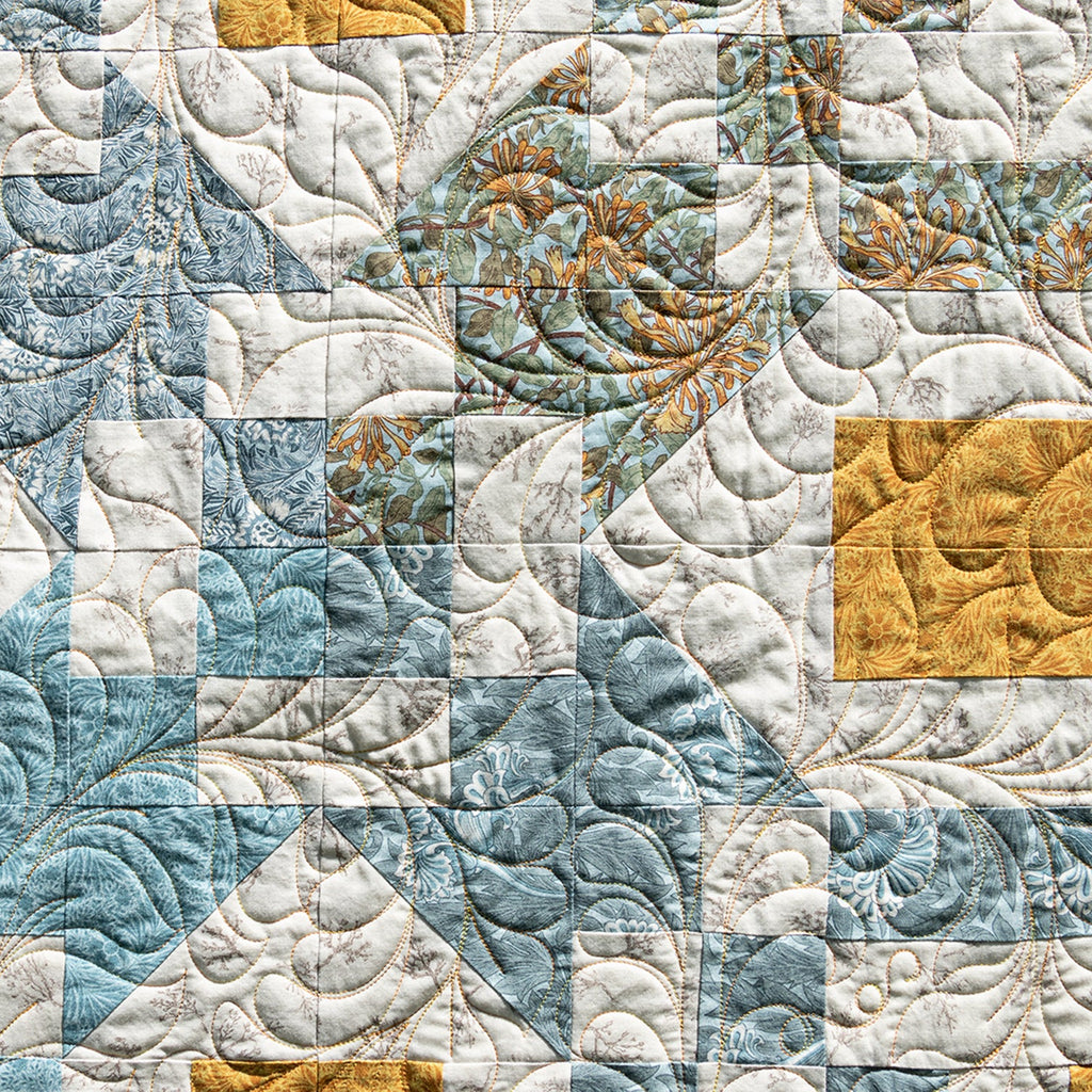 Quilt with a patchwork pattern featuring blue, white, and gold colors.