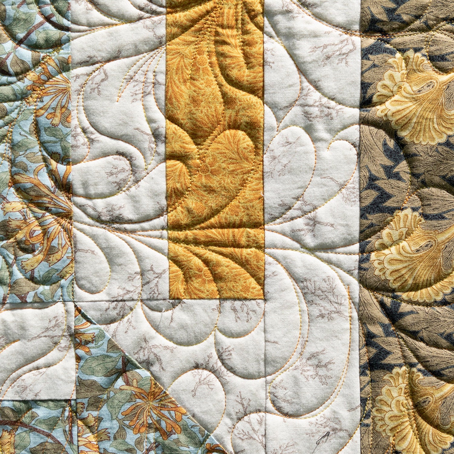 Quilt block in yellow, white and blue in a floral pattern