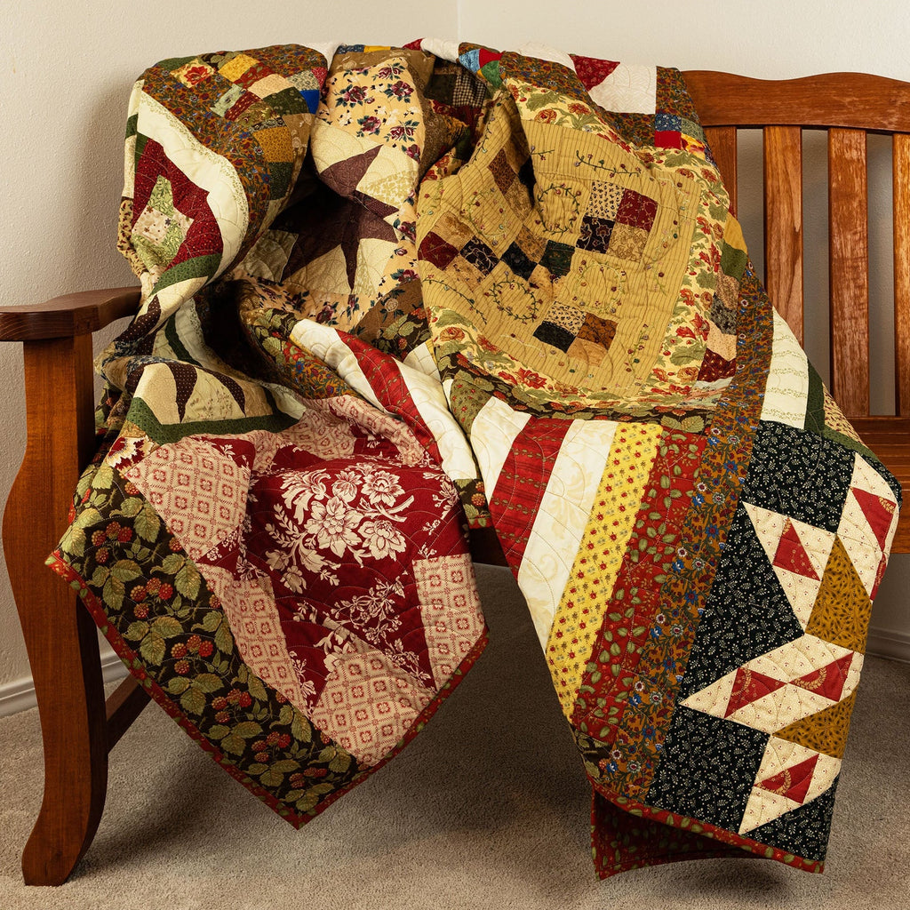 Colorful quilt draped over a wooden chair against a plain wall.