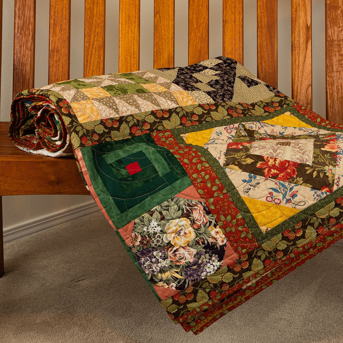 Patchwork quilt draped over a wooden bench