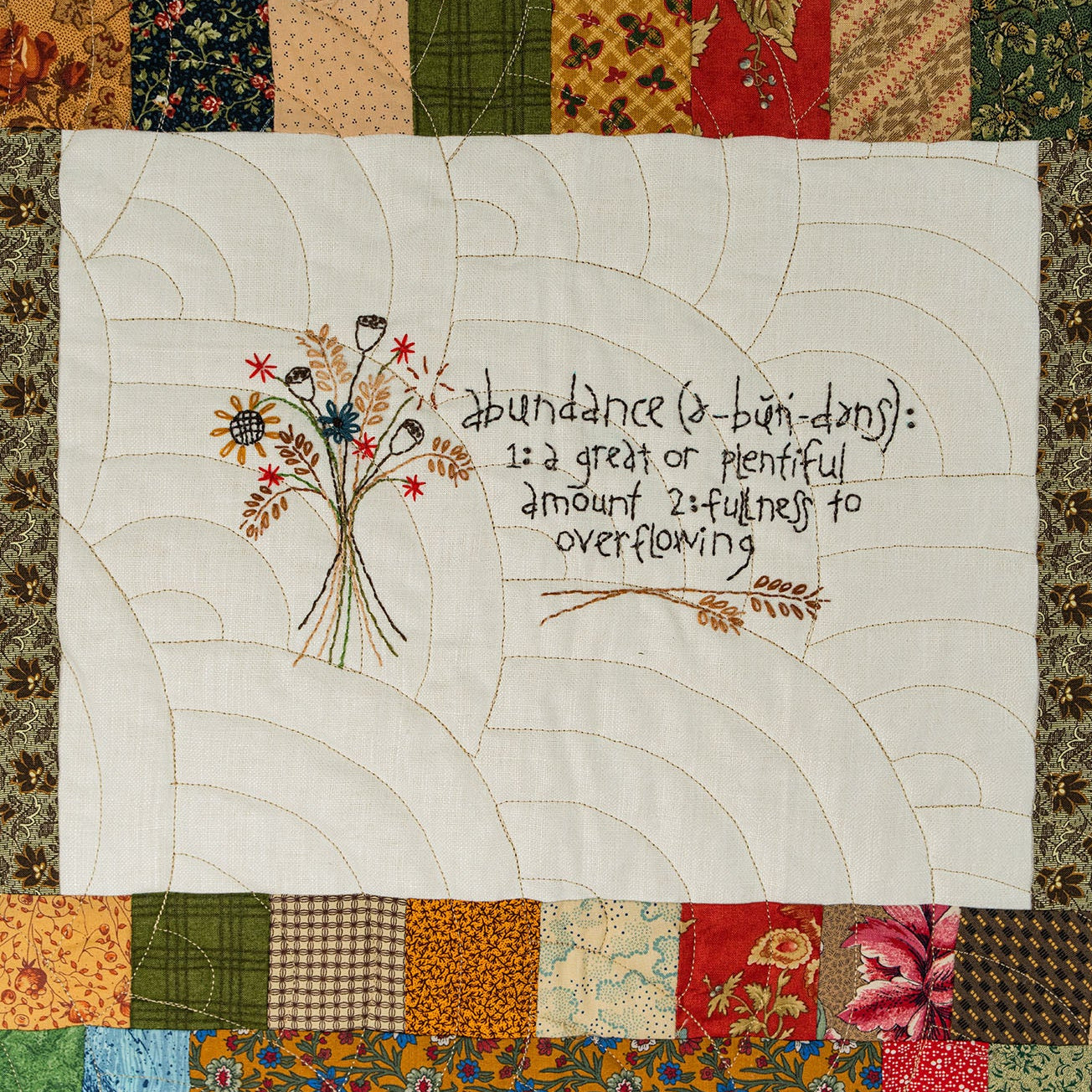 Quilt with floral design and text on a patchwork border
