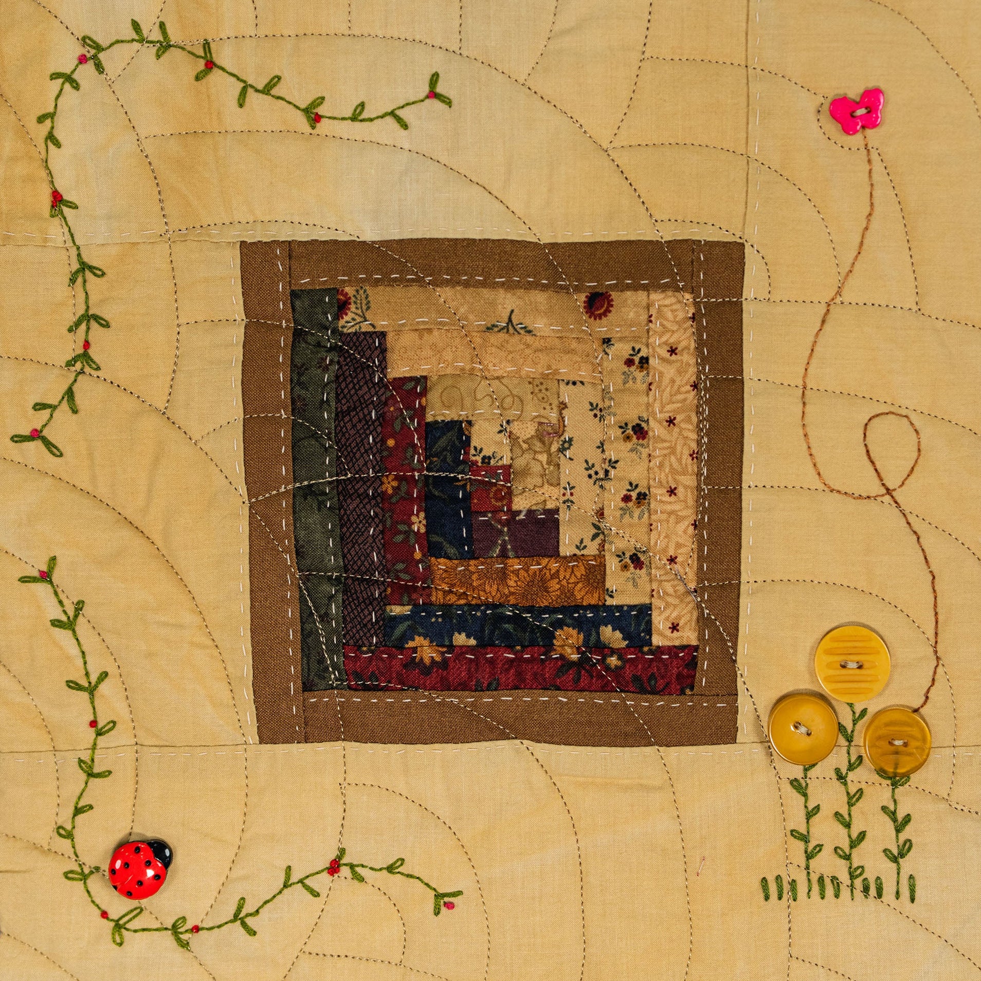 Patchwork quilt with floral and ladybug designs on a beige background