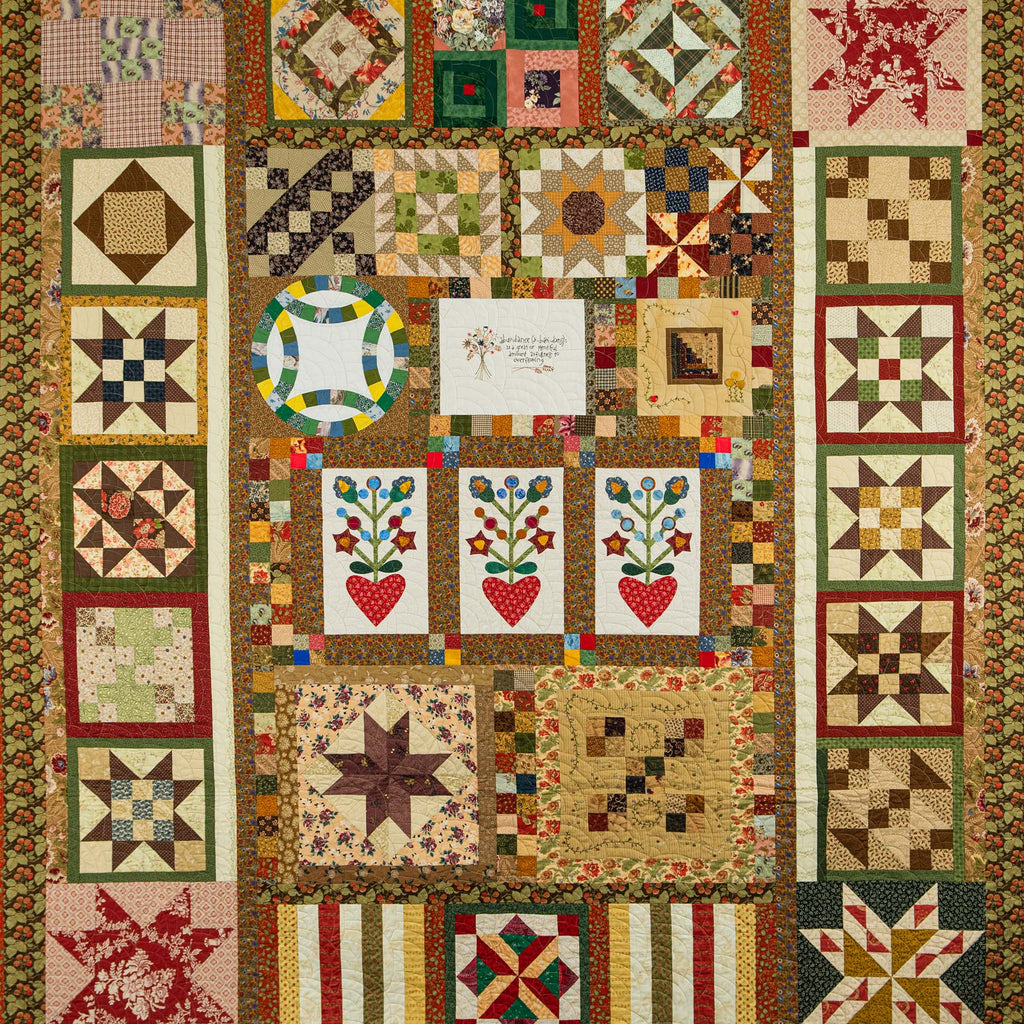 Quilt with various geometric and floral patterns in a patchwork design.