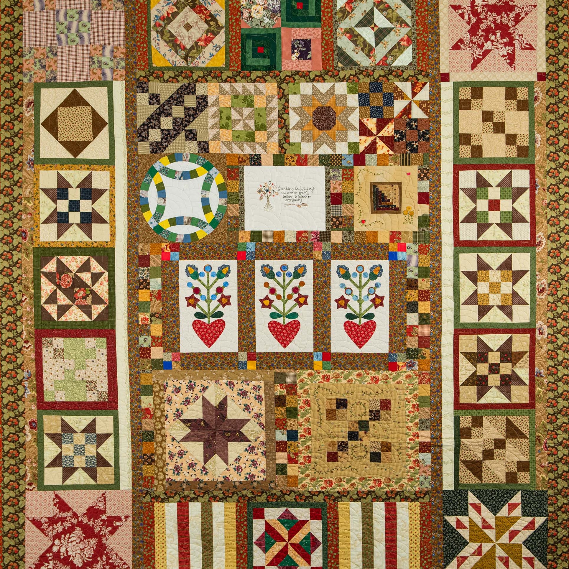 Quilt with various geometric and floral patterns in a patchwork design.