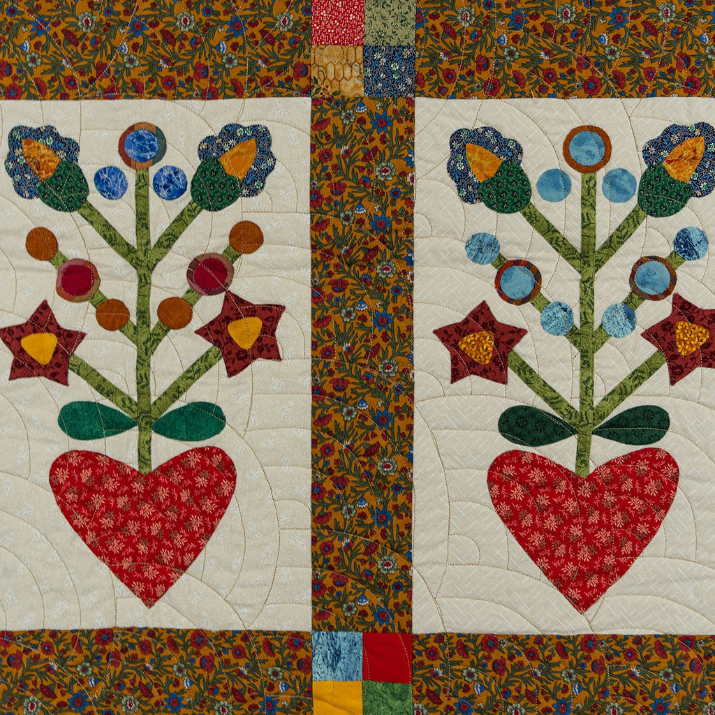 Quilt with floral design and red heart on a colorful patchwork background