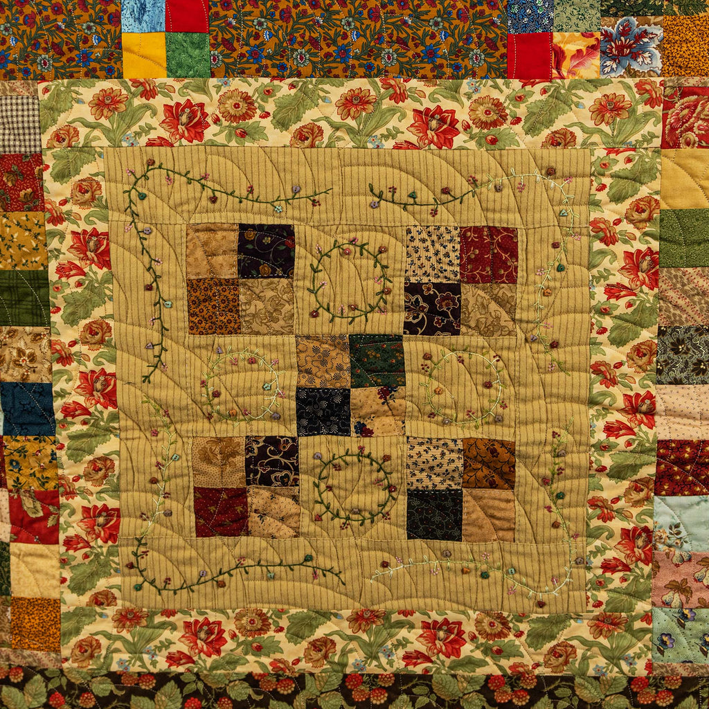 Patchwork quilt with floral patterns and a heart design