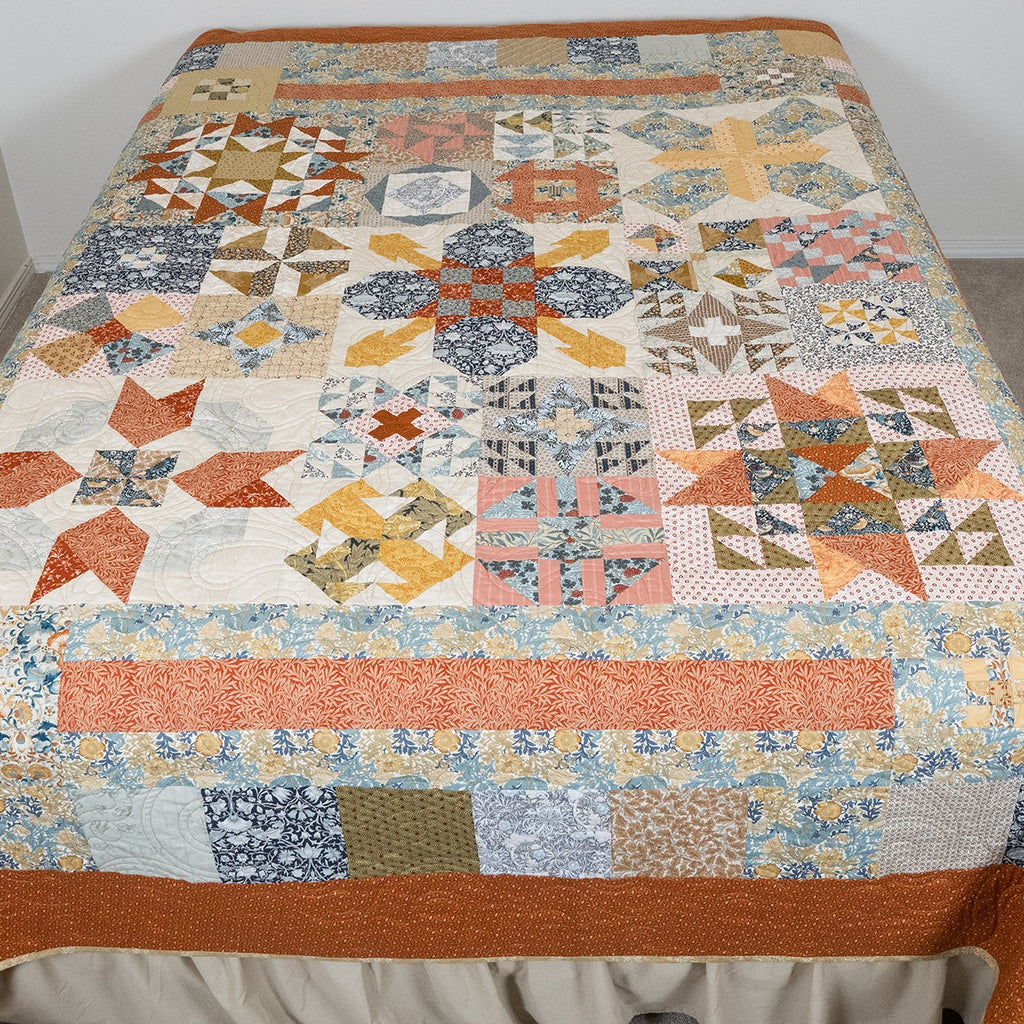 Quilt with star pattern on a bed in a room.