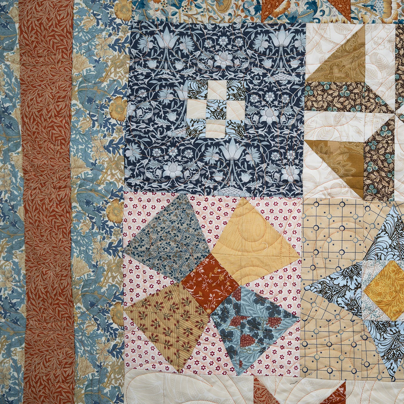 Quilt with geometric pattern featuring various colors and textures