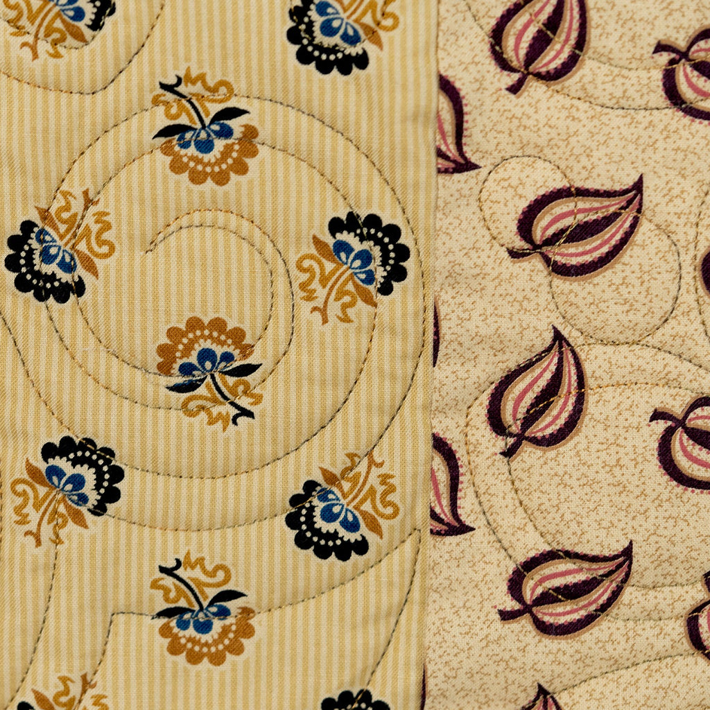 Two patterns of fabric with floral and leaf designs on a beige background.