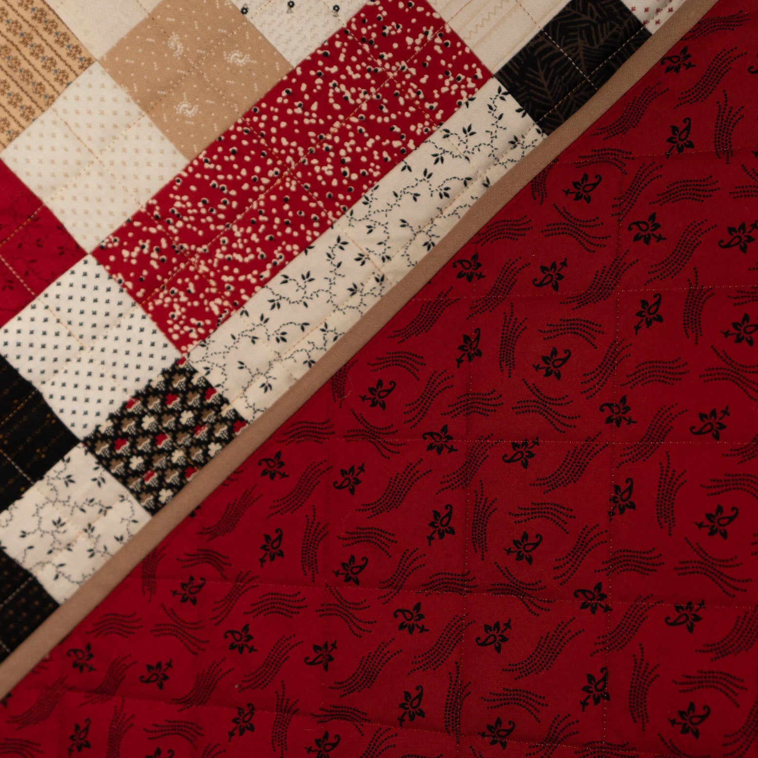 Quilt with red, black, and white patterned fabric