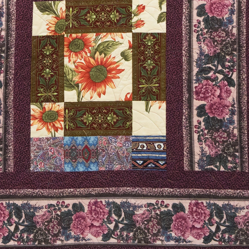 Quilt with floral and geometric patterns on a dark background