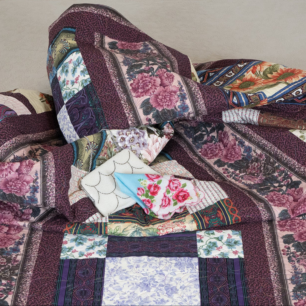 Patchwork quilt with floral patterns on a beige surface