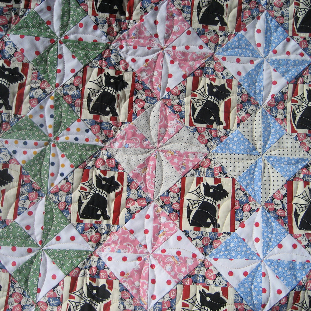 Quilt with geometric pattern featuring black dog designs on a multicolored background