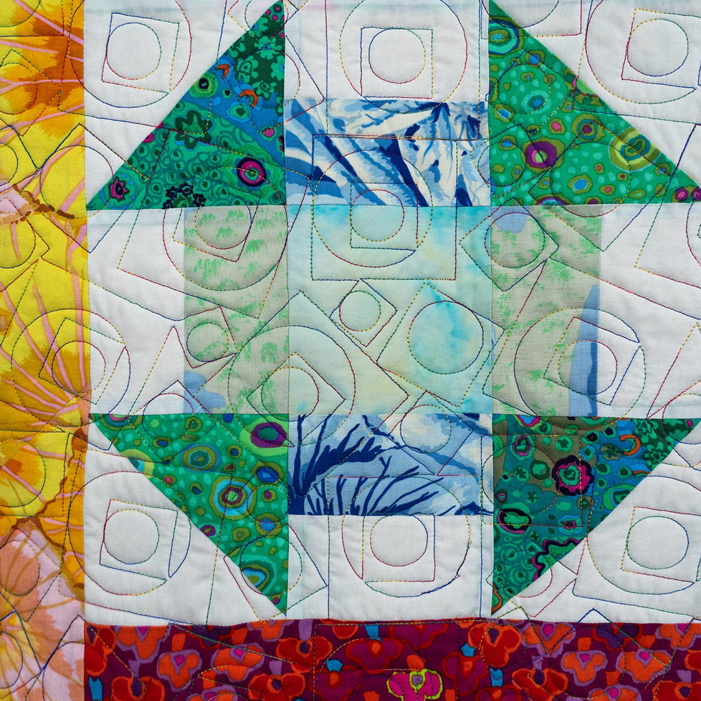 Colorful quilt with geometric patterns and a house design.