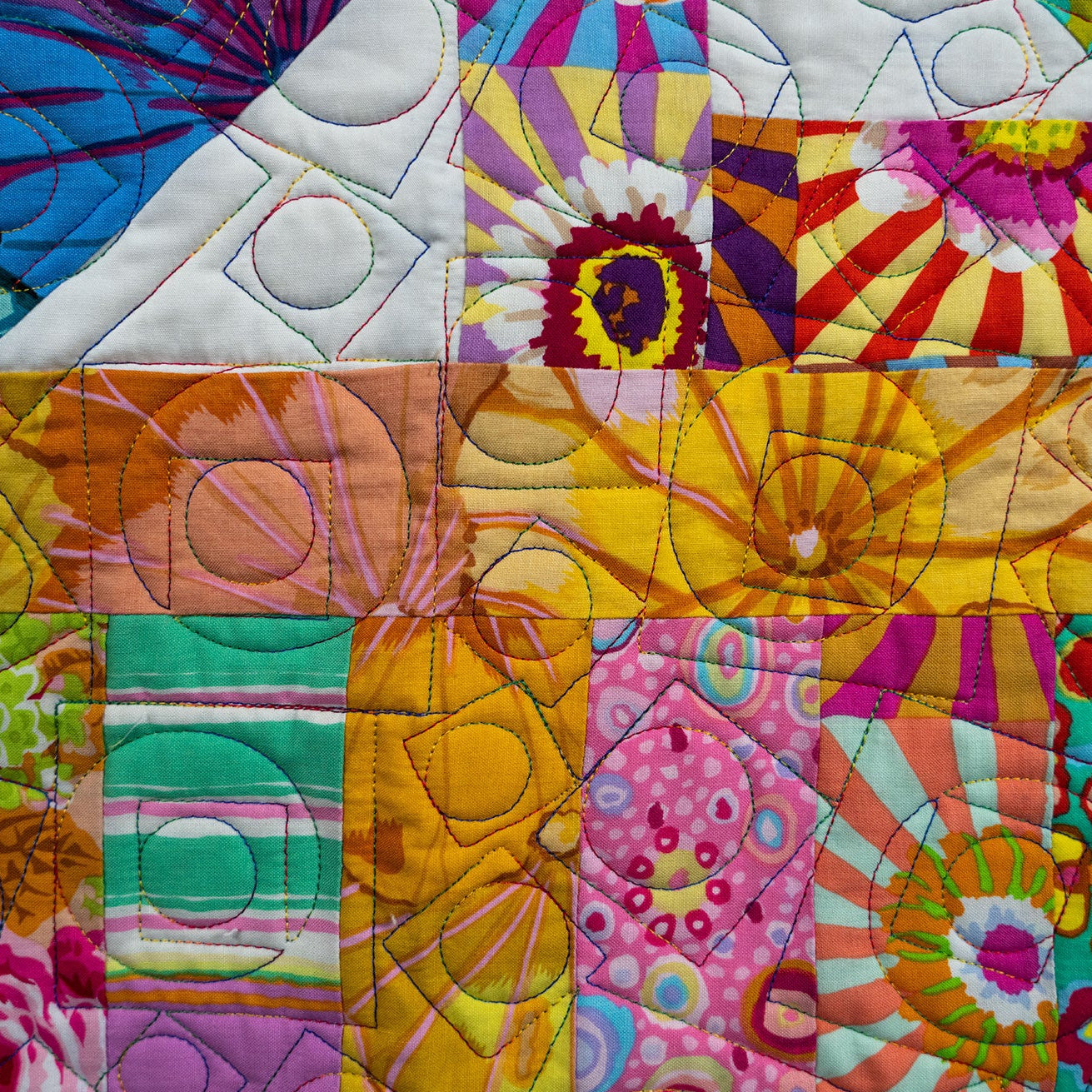 Colorful quilt with floral and abstract patterns