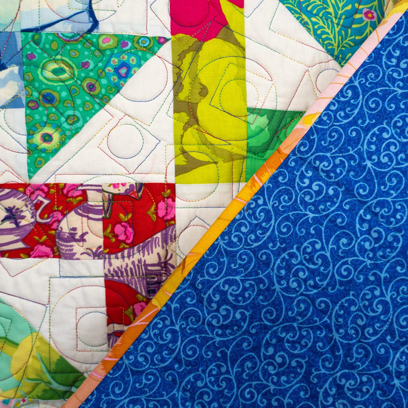 Colorful patchwork fabric with geometric patterns on a blue background