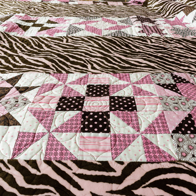 Quilt block with a geometric centre print with animal print border in pink and brown