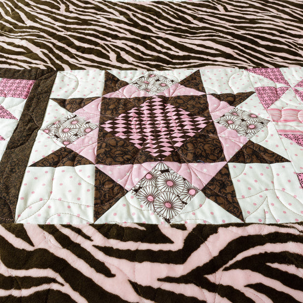 Quilt block with a geometric centre print with animal print border in pink and brown