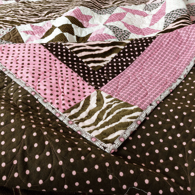 Quilt backing in a pink and brown polkadot print, with geometric and animal print front side