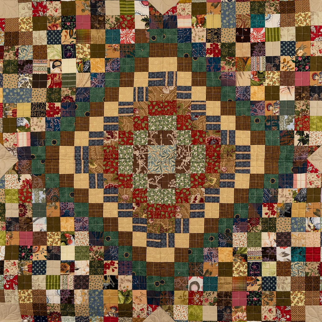 Patchwork quilt with multicolored squares and a beige border