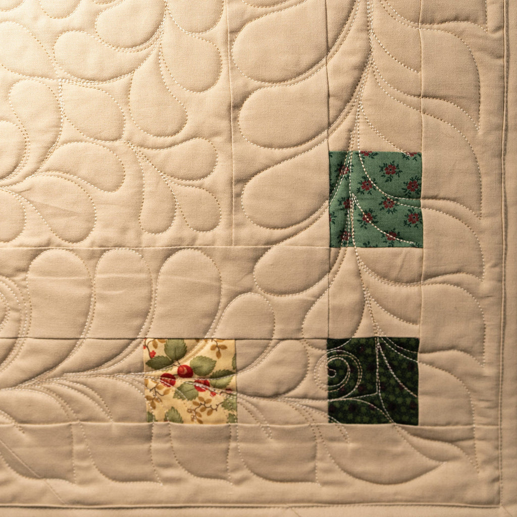 Quilt with intricate stitching and colorful square patterns on a beige background