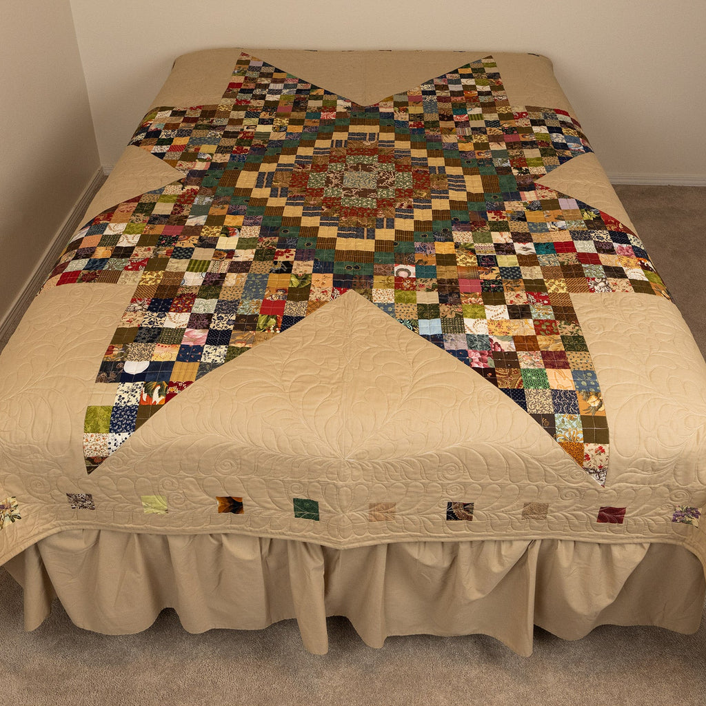 Bed with a patchwork quilt on a plain background