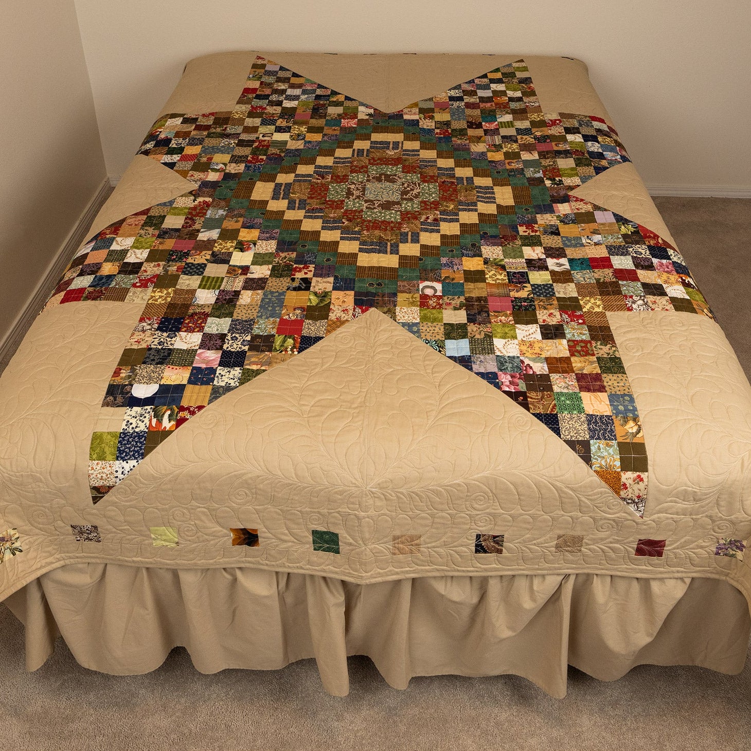 Bed with a patchwork quilt on a plain background