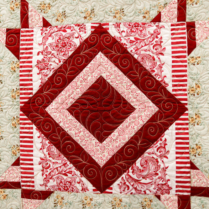 Quilt with red and white geometric pattern on a floral background