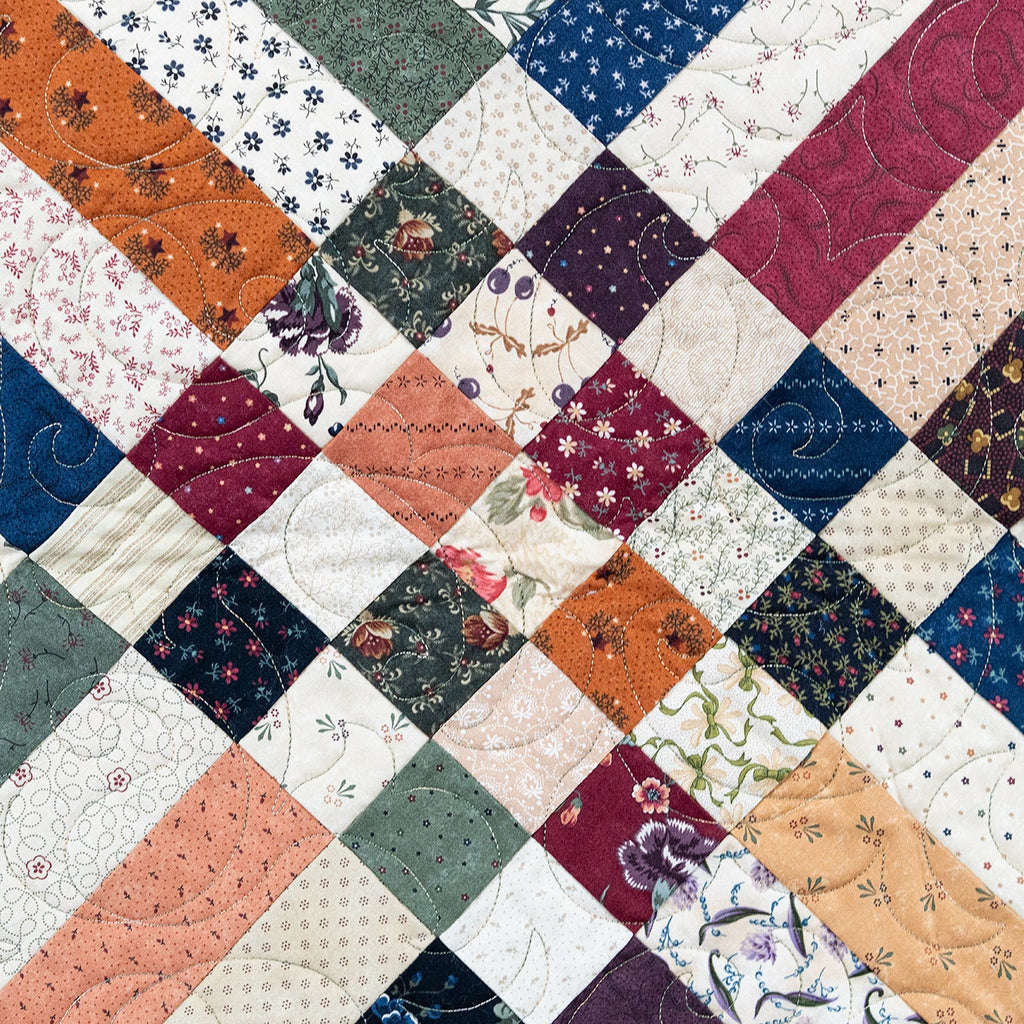 Patchwork quilt with floral patterns in various colors