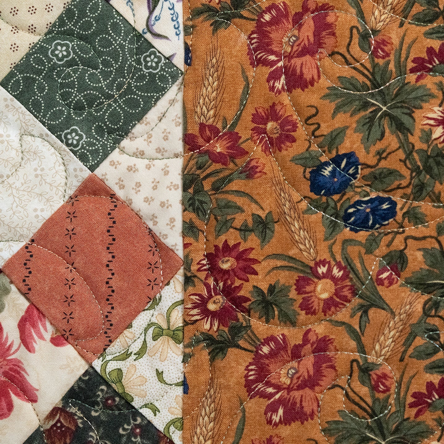 Close-up of a patchwork quilt with floral and geometric patterns.