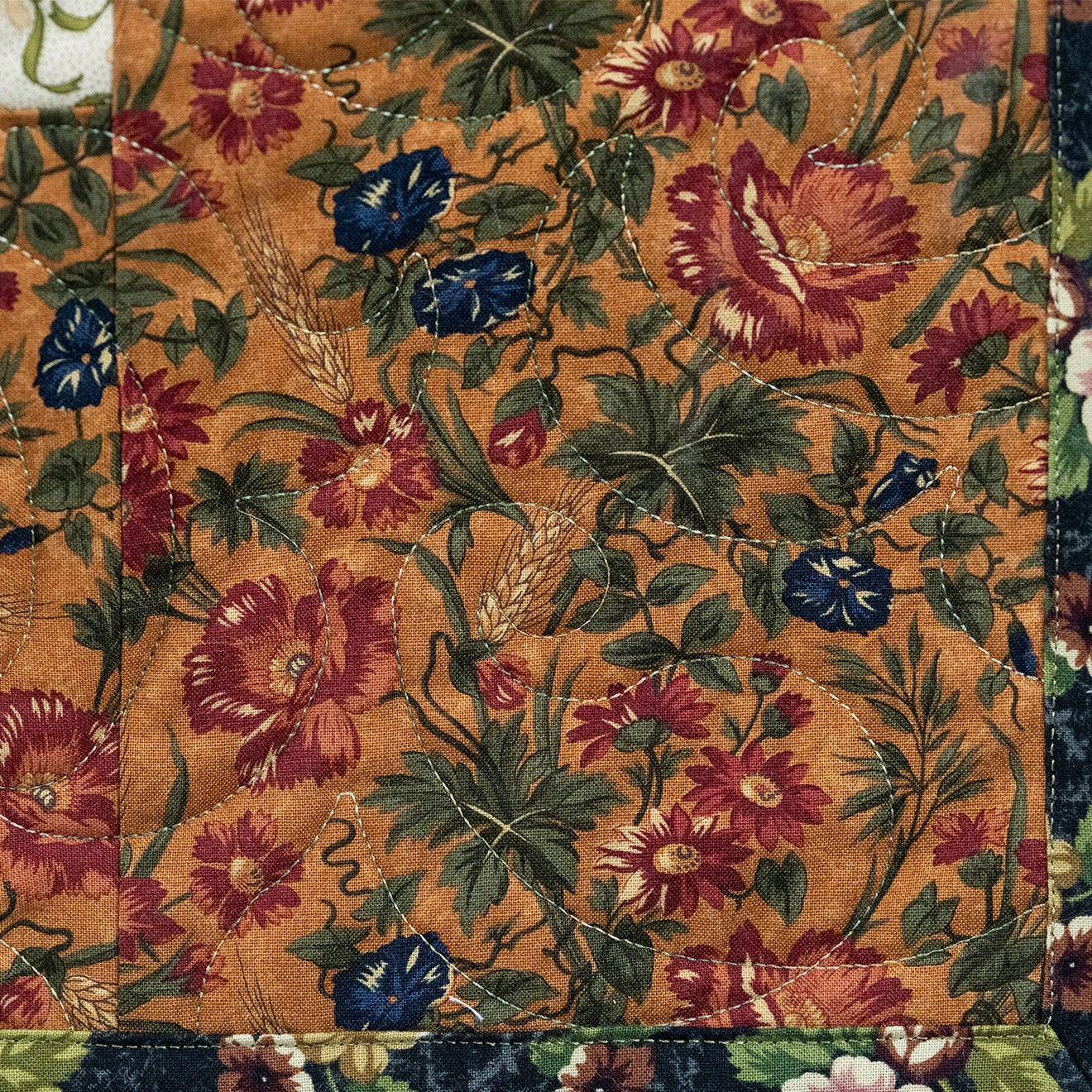 Floral patterned fabric with red, blue, and green flowers on a brown background