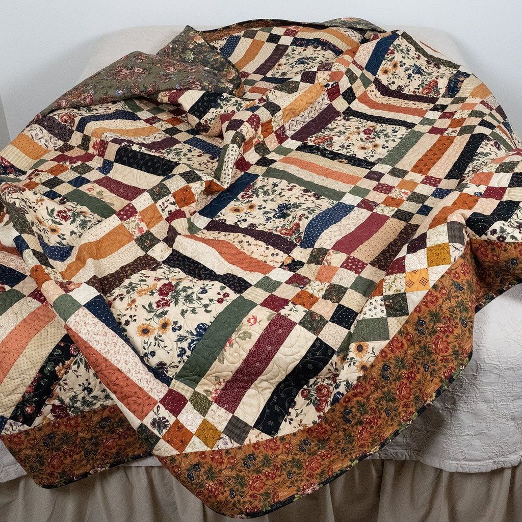 Colorful quilt draped over a chair against a white wall