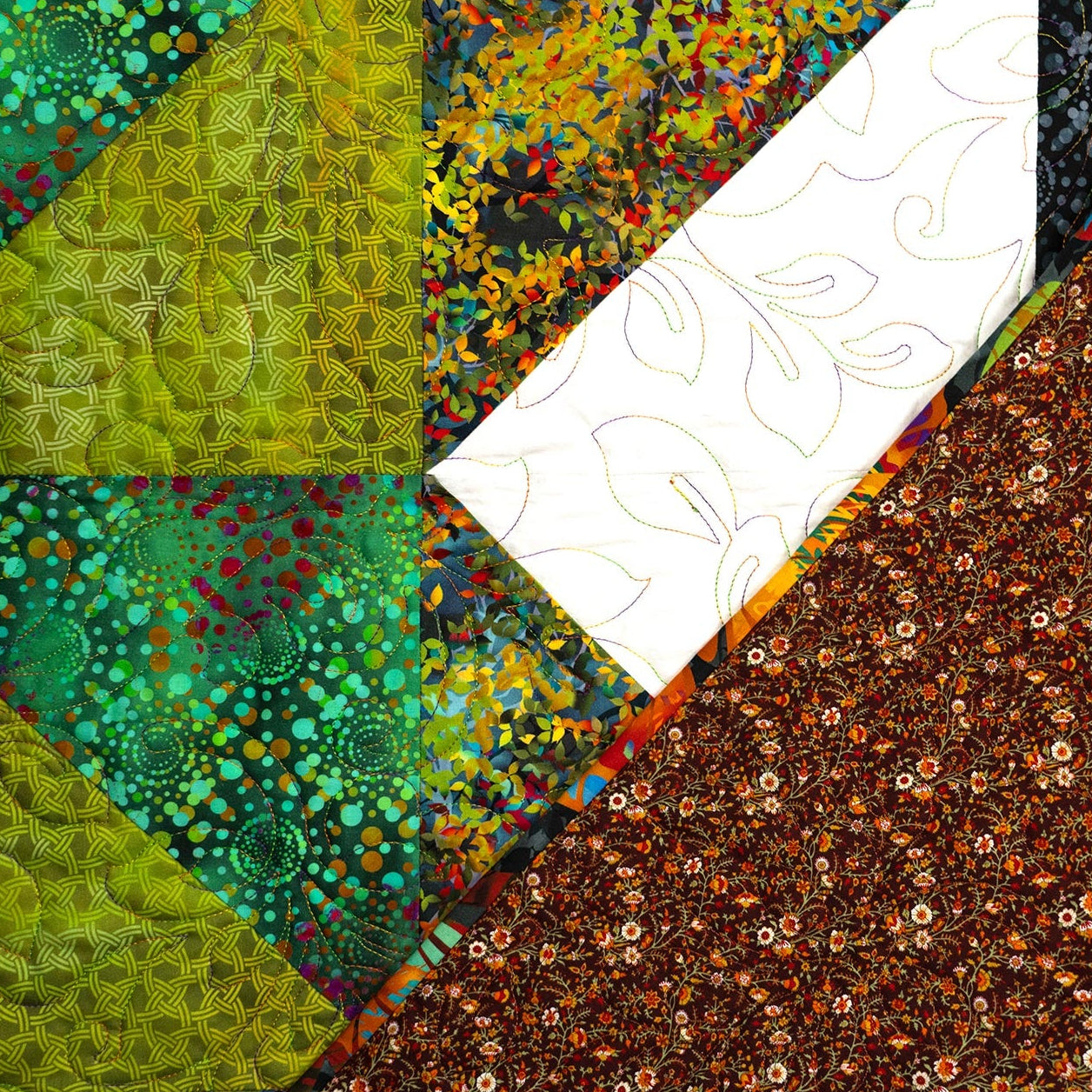 Colorful quilt with geometric patterns and a white border.