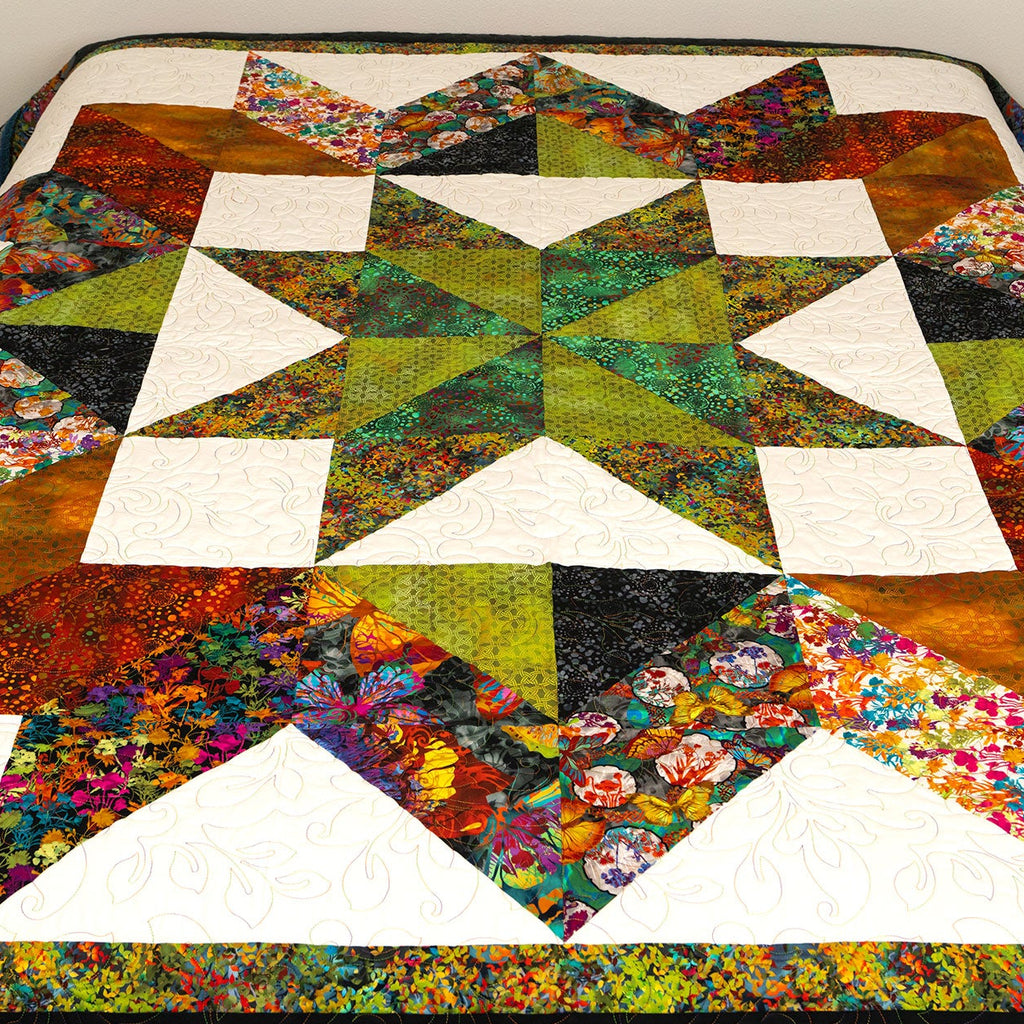 Colorful star-shaped quilt on a bed with a plain background