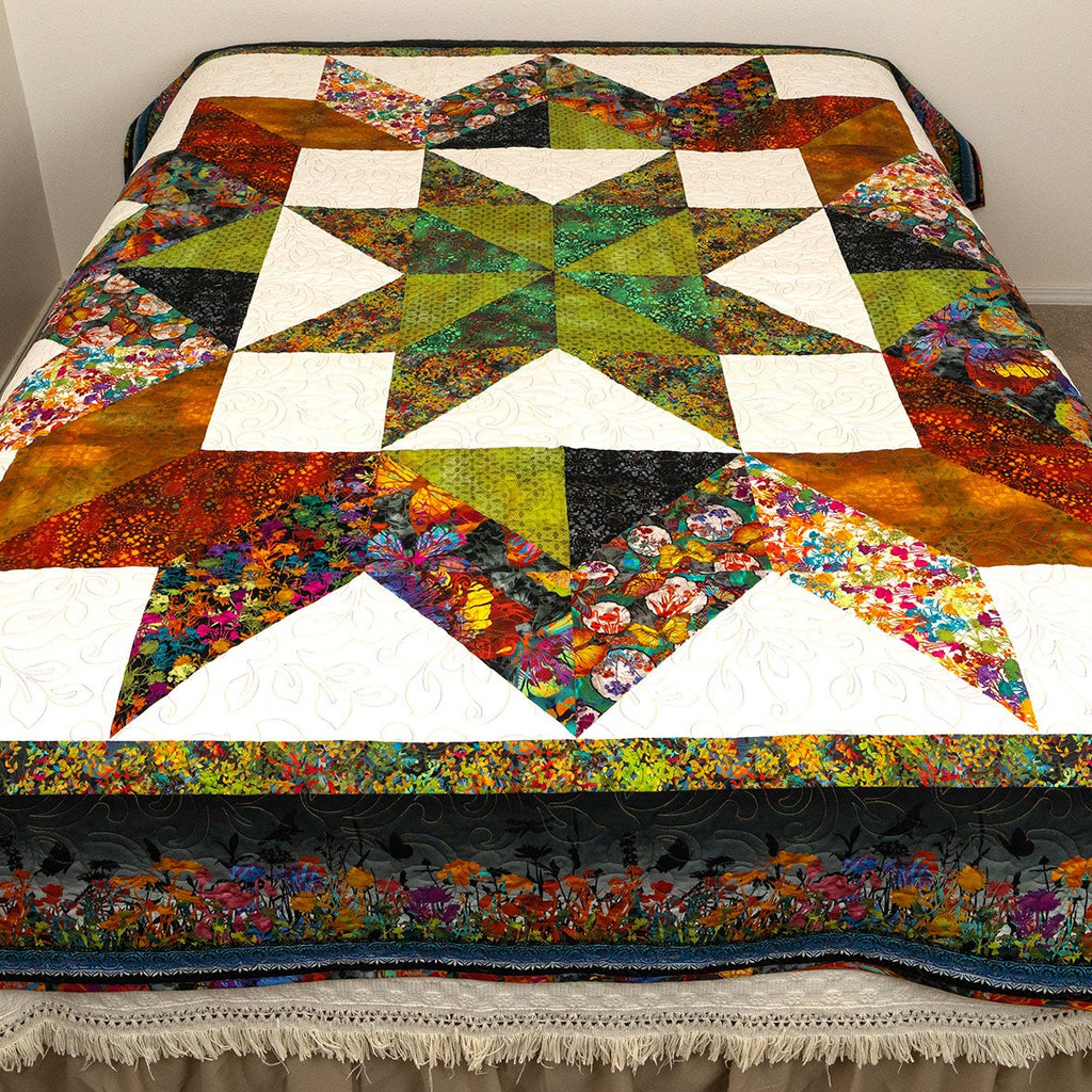 Colorful quilt with star pattern on a bed in a room.